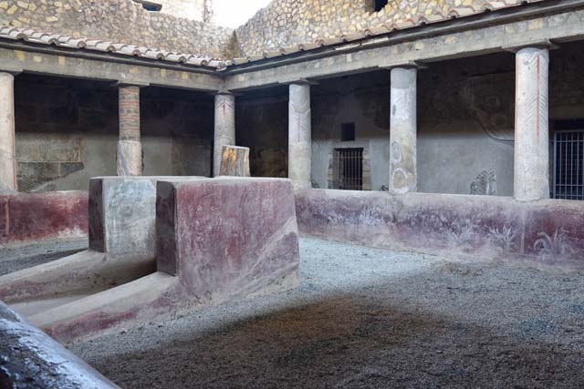 Oplontis, September 2015. Room 32, doorway to room 42, steps to upper floor, on east side of internal peristyle.  Steps leading to a mezzanine floor above rooms 43 and 44. The upper floor would have consisted of three small rooms and a corridor. 

