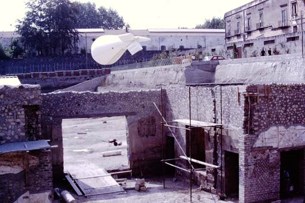 Oplontis, 1977. Looking north-west towards the balloon flying above north garden.
In the centre under the balloon is the doorway from room 69. On the right of doorway 69, is a doorway to room 71, the window into room 70 a small courtyard garden, and doorway to room 72. Photo by Stanley A. Jashemski.   
Source: The Wilhelmina and Stanley A. Jashemski archive in the University of Maryland Library, Special Collections (See collection page) and made available under the Creative Commons Attribution-Non Commercial License v.4. See Licence and use details. J77f0309
