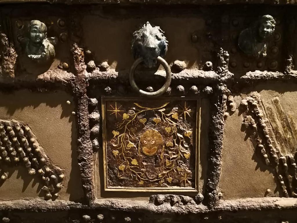 Oplontis, Villa of Lucius Crassius Tertius. December 2019. Strongbox decoration of inlaid silver and copper head of the satyr Silenus surrounded by twisting vines in centre. 
On display in exhibition “Pompei e Santorini” in Rome, 2019. Photo courtesy of Giuseppe Ciaramella.

