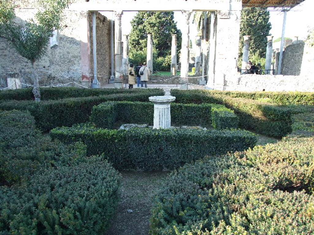 VI.12.2 Pompeii. December 2006. Looking north across first garden from rear of tablinum window, towards exedra and rear peristyle. According to Jashemski, this peristyle was enclosed on all four sides by a portico supported by twenty-eight columns covered with fine white stucco.
These columns were in the process of being repaired at the time of the eruption. In the middle of the garden was a base of a marble fountain, from which water jetted into a shallow pool. See Jashemski, W. F., 1993. The Gardens of Pompeii, Volume II: Appendices. New York: Caratzas. (p.145)