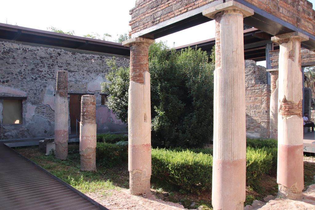 HGW24 Pompeii. Villa of Diomedes. October 2023. Looking towards south-west corner of peristyle, behind bush. Photo courtesy of Klaus Heese.

